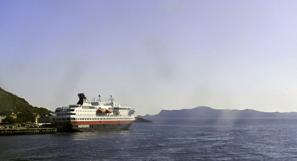 Hurtigruten ved kai i Havøysund fredag morgen den 19. juli 2024. I løpet av dagen ventes det 22 grader. Svak skiftende østlig vind, melder yr.no. (Skjermklipp fra kystnor.no)
